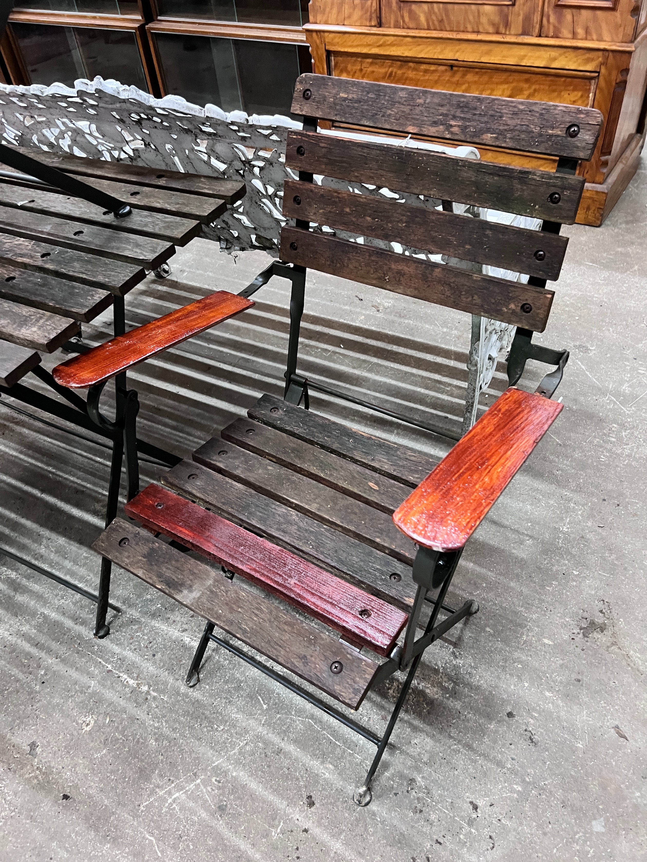 A slatted wood and wrought iron rectangular folding garden table, length 122cm, depth 68cm, height 71cm and four chairs *Please note the sale commences at 9am.